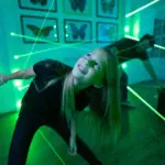 Smiling girl weaving through laser beams at Escapology escape room in Orlando.